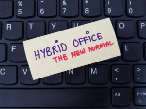 Hybrid working written on Post-It note slapped on laptop keyboard