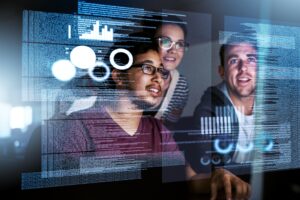 tech careers concept. Three software engineers looking excitedly at code superimposed on screen